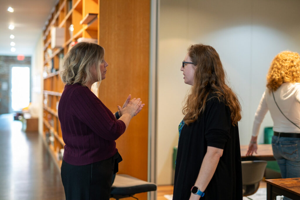 Tara May talks to a female employee in the Aspiritech office.