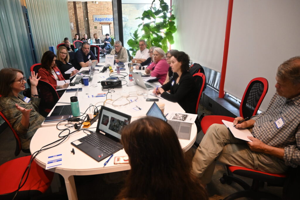 group of executives around a large table in an informal training session
