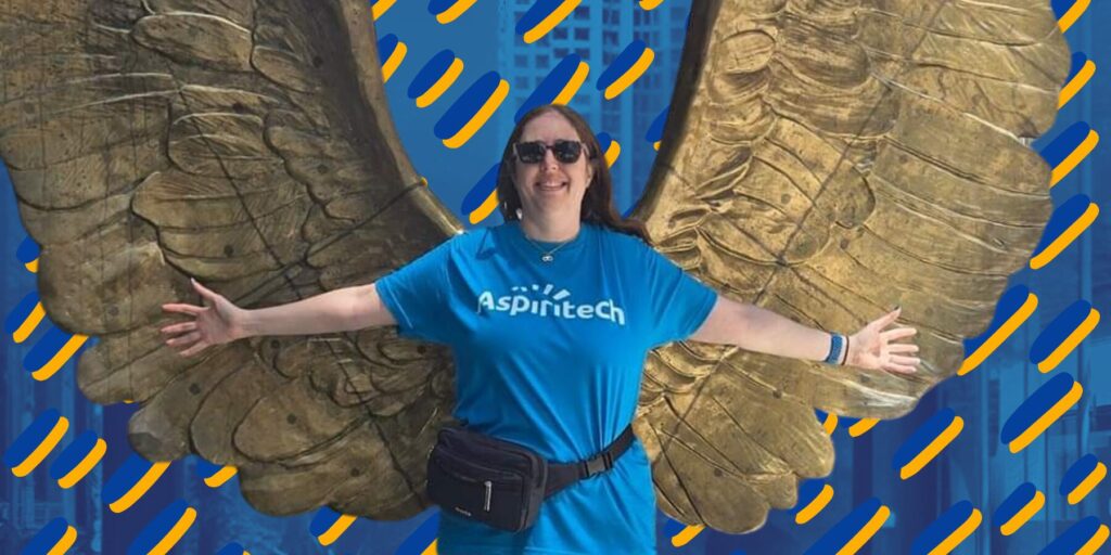 Aspiritech's Katie Levin standing in front of a golden-winged statue.