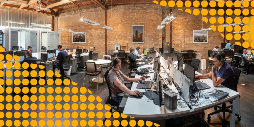 Employees work at long desks in the Aspiritech office in Evanston, Illinois.