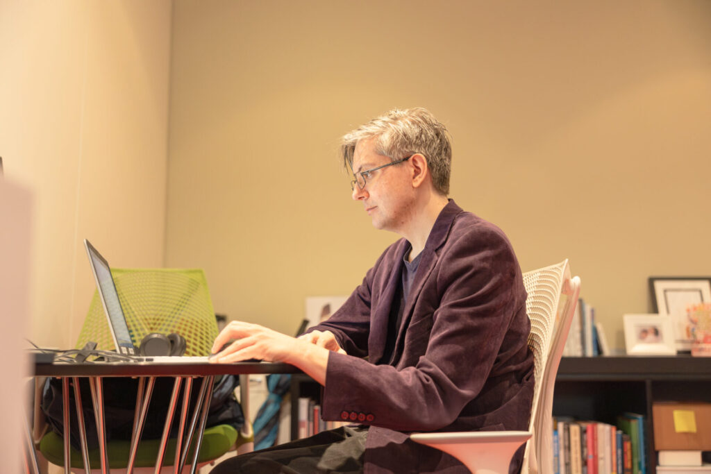 A male Aspiritech employee works at a laptop.