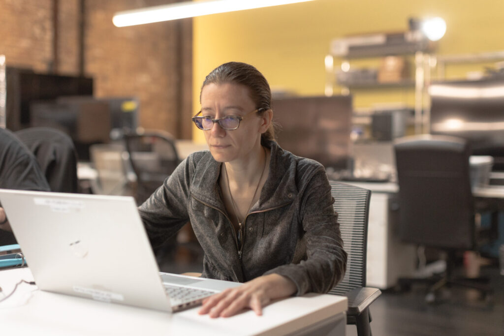 A female Aspiritech employee looks at her laptop.